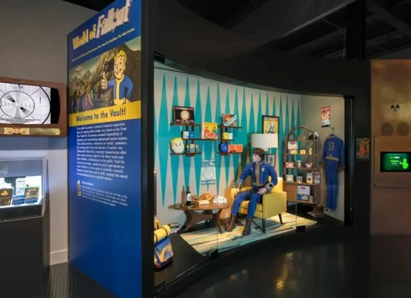 "World of Fallout" exhibit featuring a Vault-Tec diorama with a mannequin in a Vault suit and retro memorabilia.
