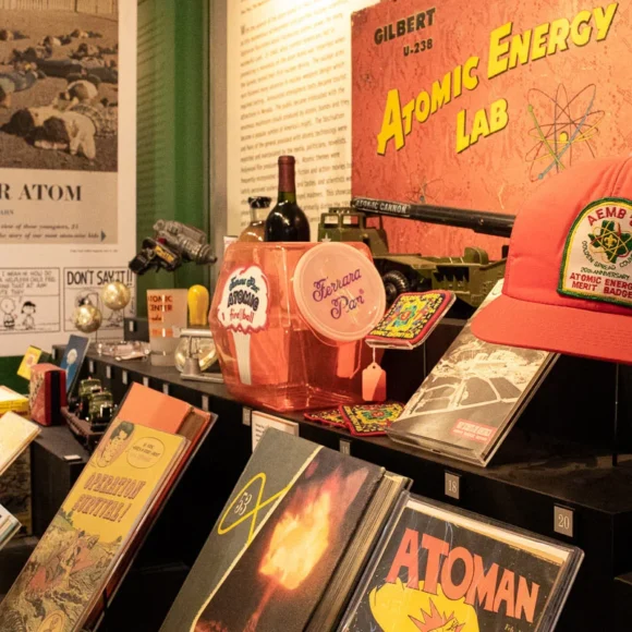 Vintage atomic-themed pop culture memorabilia, comic books, and a red hat on display.