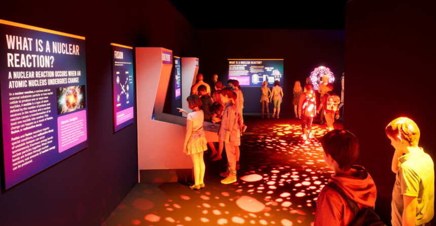 Atomic Museum interactive exhibit in Las Vegas Visitors exploring the immersive Atomic Odyssey exhibit at the Atomic Museum in Las Vegas, featuring interactive STEM displays and vibrant lighting.