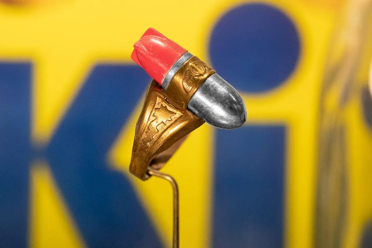 Vintage toy ring with a bomb-shaped design mounted on a stand.