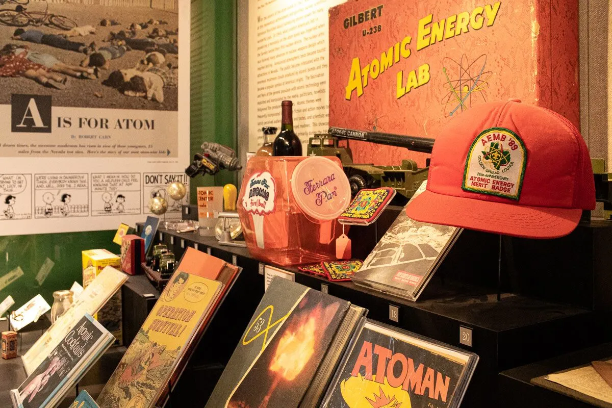 Vintage atomic-themed pop culture memorabilia, comic books, and a red hat on display.