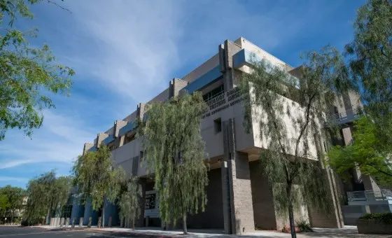 Exterior view of the Atomic Testing Museum building framed by trees.