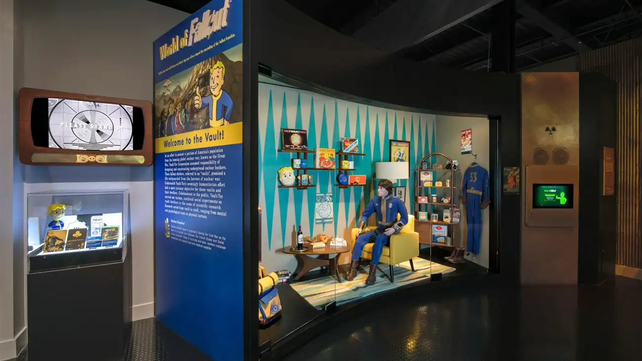 "World of Fallout" exhibit featuring a Vault-Tec diorama with a mannequin in a Vault suit and retro memorabilia.