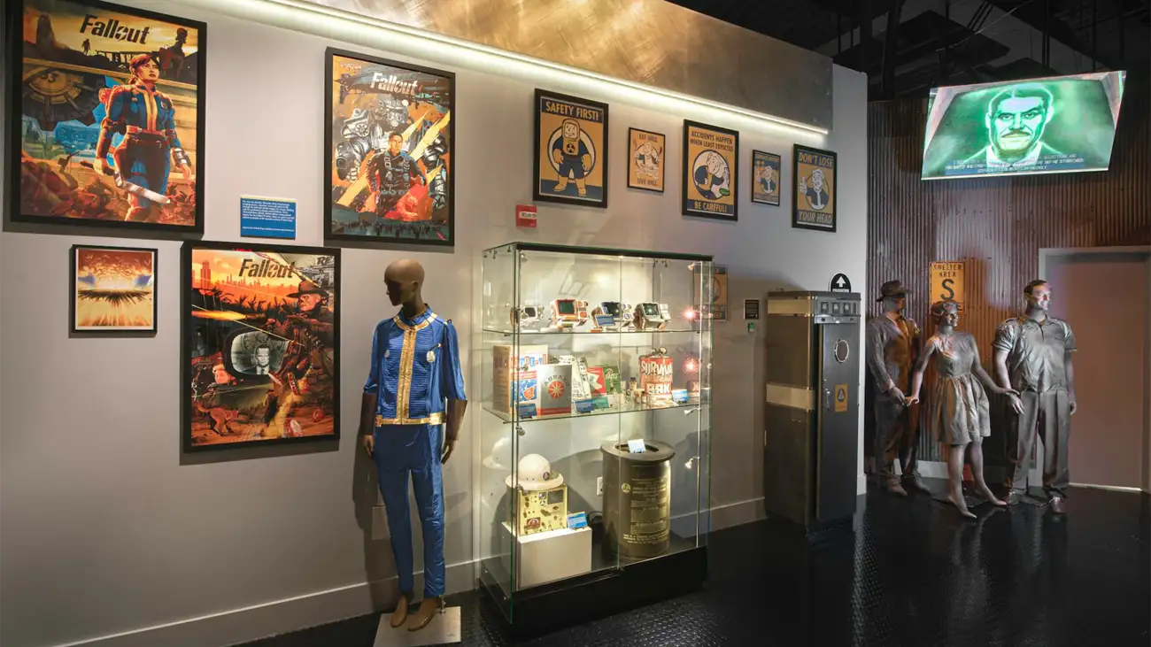 Fallout gallery with posters, Vault suit, and statues.